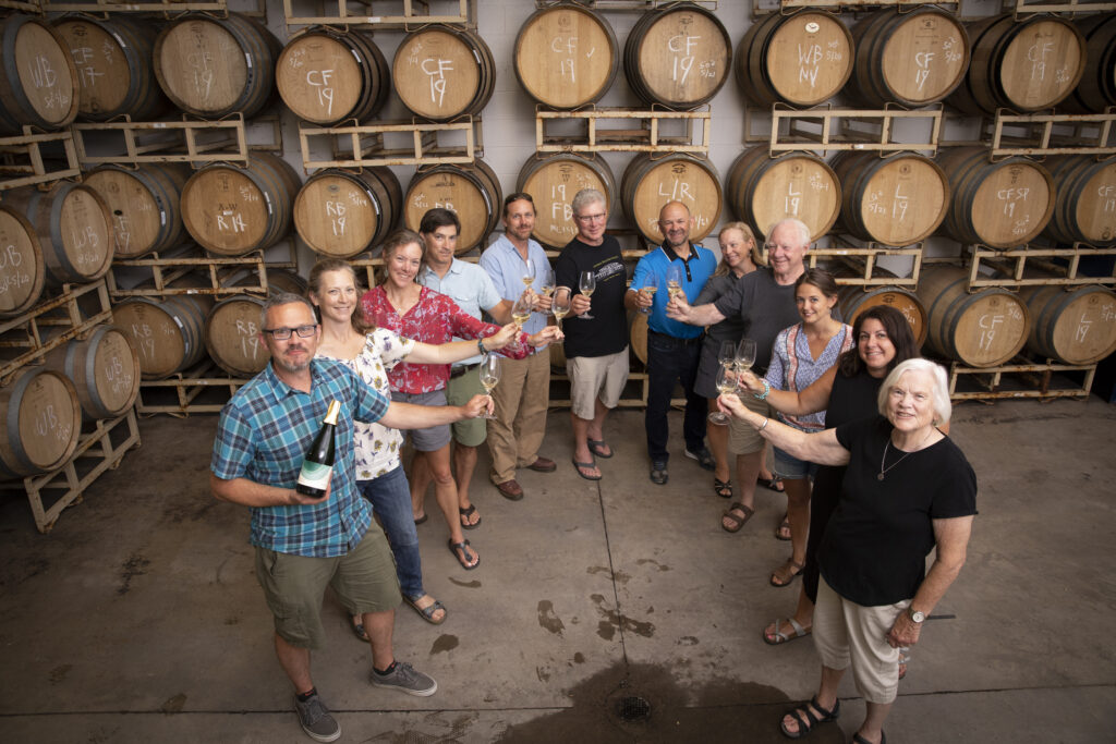 Members of the Anthony Road family and team toasting sparkling wine in the barrel room